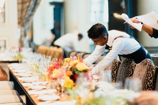 Restaurant staff preparing an elegant outdoor dining table